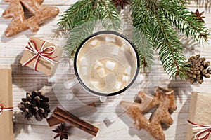 Hot Christmas drink with marshmallows in an iron mug and gingerbread cookies, on a white table. New Year, holiday background,