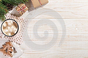 Hot Christmas drink with marshmallows in an iron mug and gingerbread cookies, on a white table. New Year, holiday background, copy