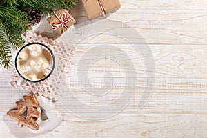 Hot Christmas drink with marshmallows in an iron mug and gingerbread cookies, on a white table. New Year, holiday background, copy