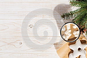 Hot Christmas drink with marshmallows in an iron mug and gingerbread cookies, on a white table. New Year, holiday background, copy