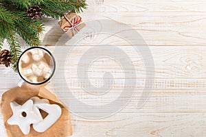 Hot Christmas drink with marshmallows in an iron mug and gingerbread cookies, on a white table. New Year, holiday background, copy