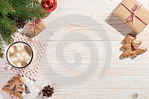 Hot Christmas drink with marshmallows in an iron mug and gingerbread cookies, on a white table. New Year, holiday background, copy
