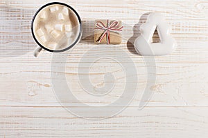 Hot Christmas drink with marshmallows in an iron mug and gingerbread cookies, on a white table. New Year, holiday background, copy