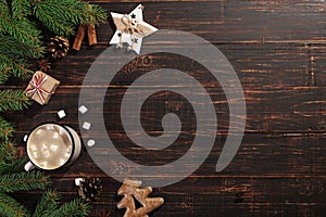 Hot Christmas drink with marshmallows in iron mug and gingerbread cookies, on a wooden table. New Year, holiday background,