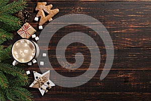 Hot Christmas drink with marshmallows in iron mug and gingerbread cookies, on a wooden table. New Year, holiday background,