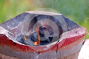 Hot coals in a brazier to prepare for cooking in outdoor space with smoke