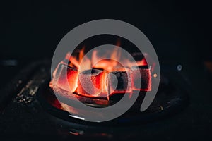 Hot coals for Shisha warmed up on the stove in a hookah bar photo