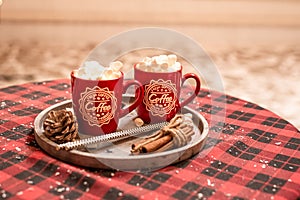 Hot cocoa with marshmallows in a Christmas cup. Hot chocolate wiht white marshmalows in a New Year`s cup. New Year 2020