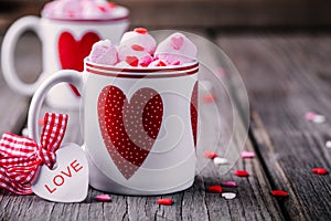 Hot cocoa with pink marshmallow in mugs with hearts for Valentine day