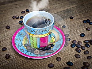 Hot coffe in Cup with Saucer and coffee beans on wooden table