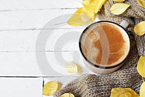 Hot coffee and autumn leaves on white wood background - seasonal relax concept