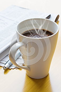 Hot coffee, ball-point and newspaper