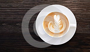 Hot coffee cappuccino latte art top view on dark wooden table background