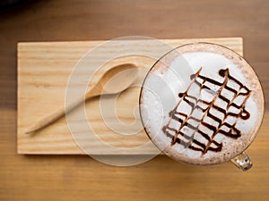 Hot coffee or chocolate served with milk foam and wooden saucer