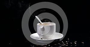Hot coffee and coffee beans on the desk with black background