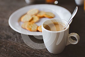 Hot coffee with crackers on wooden table