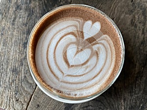 Hot coffee cup with art froth milk heart  on top