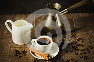 Hot coffee cup with cinnamon sticks with a creamer and old pot/hot coffee cup with cinnamon sticks with a creamer and old pot on a