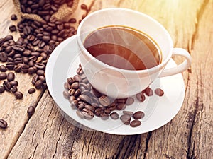 Hot coffee cup with coffee bean on wooden table. coffee bg