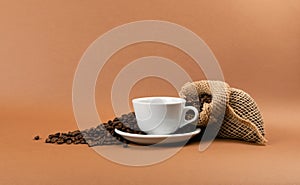 Hot coffee cup and coffee beans in burlap bag