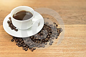 Hot Coffee cup with coffee beans with copy space on wooden table