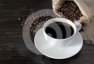 Hot Coffee cup with Coffee beans on the wooden table