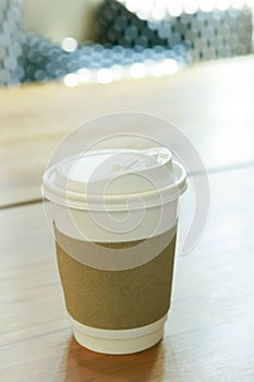 hot coffee cup cover by brown paper protect heat tempurature on wood table