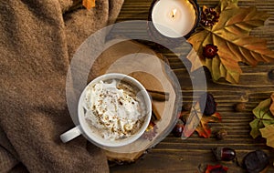 Hot coffee cup with cream and cinnamon spice, hot chocolate autumn cozy setting with soft blanket