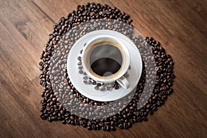 Hot coffee cup with heart pattern of roasted coffee beans