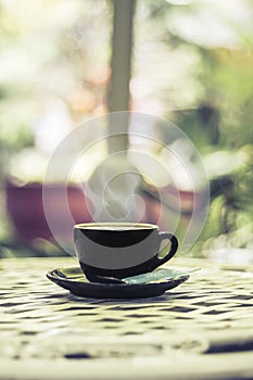 Hot coffee in the cup on morning background.