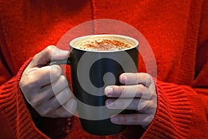 Hot coffee cup on the women hand holding in underexposure scene, food and drink concept - gain and noise filter applied