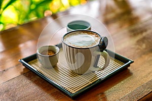 Hot coffee cup on wood table in cafe.