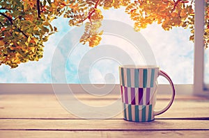 Hot coffee cup on wood table in fall season
