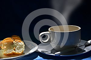 Hot coffee cup and bread dish in the light