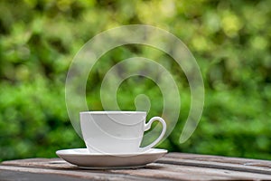 Hot Coffee Drink Concept, Hot ceramic white coffee cup with smoke on an old wooden table in a natural background