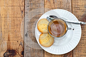 Hot coffee in glass placed on the table with cookies.