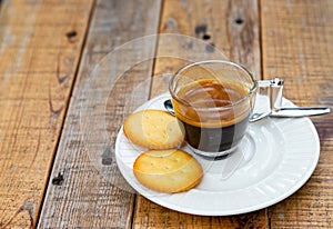 Hot coffee in glass placed on the table with cookies.