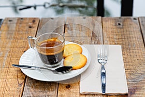 Hot coffee in glass placed on the table with cookies.