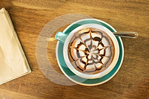 Hot coffee in green cup and saucer top view