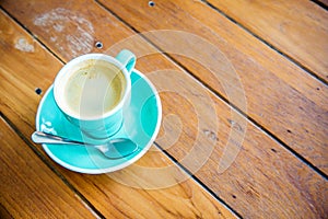 Hot coffee in a green cup with saucer on wooden table background.coffee cup on a wood background with copy space.