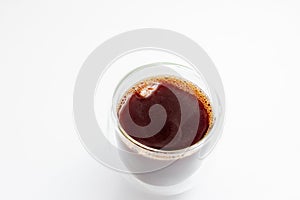 Hot coffee with ice in a glass with double walls on a white background. Selective focus