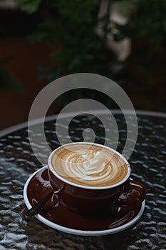 Hot coffee latte with beautiful latte art on ceramic glass in lo