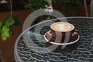 Hot coffee latte with beautiful latte art on ceramic glass in lo