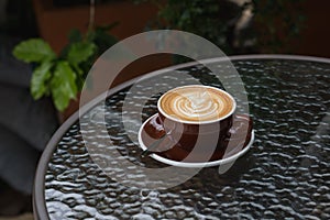 Hot coffee latte with beautiful latte art on ceramic glass in lo