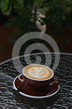 Hot coffee latte with beautiful latte art on ceramic glass in lo