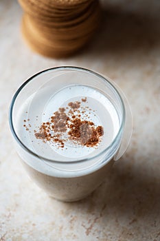 Hot coffee with milk foam and cinnamon in a transparent glass