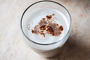 Hot coffee with milk foam and cinnamon in a transparent glass