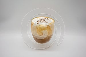 Hot coffee with milky foam sprinkle with cocoa power for decoration in double wall glass isolated on white