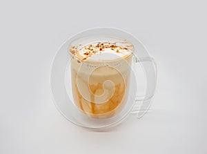 Hot coffee with milky foam sprinkle with cocoa power for decoration in double wall glass isolated on white