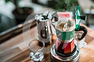 Hot coffee In Moka Pot on electric stove ,vintage coffee maker on wooden table at home, Selective focus